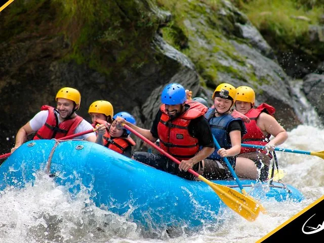 Groupe de personnes faisant du rafting en eaux vives sur une rivière au courant rapide